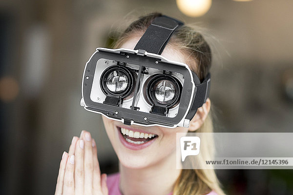 Happy young woman wearing VR glasses