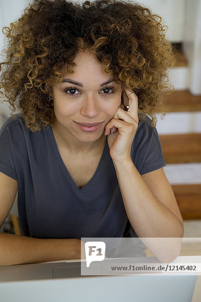Porträt einer lächelnden jungen Frau mit Laptop