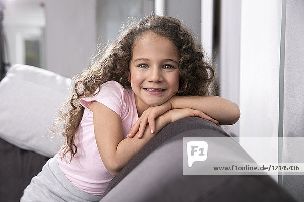 Porträt des lächelnden Mädchens mit Zahnlücke auf der Couch