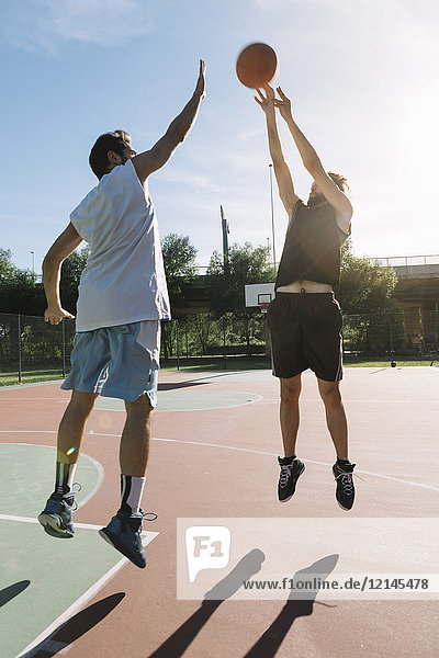 Männer spielen Basketball