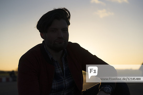 Portrait of young man outdoors at sunset