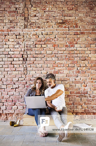 Businessman and woman sitting in a loft  using laptop  founding a start-up company