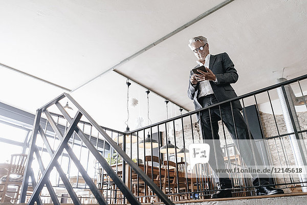 Senior Geschäftsleute am Geländer stehend  mit digitalem Tablett