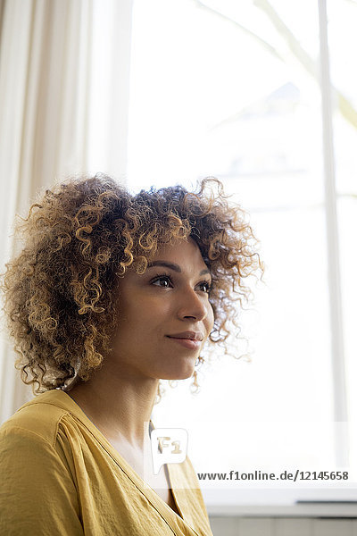 Portrait of smiling young woman at the window