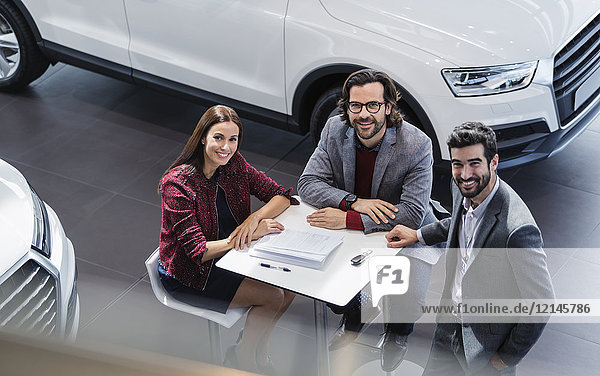 Portrait lächelnde Autoverkäufer treffen sich im Autohaus-Showroom