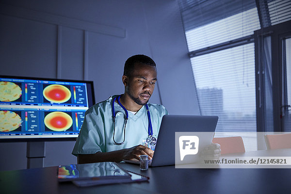 Fokussierter Chirurg am Laptop im Krankenhaus