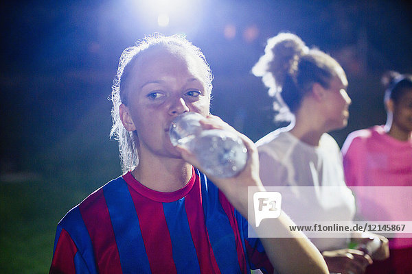 Junge Fußballspielerin beim Trinken aus der Wasserflasche