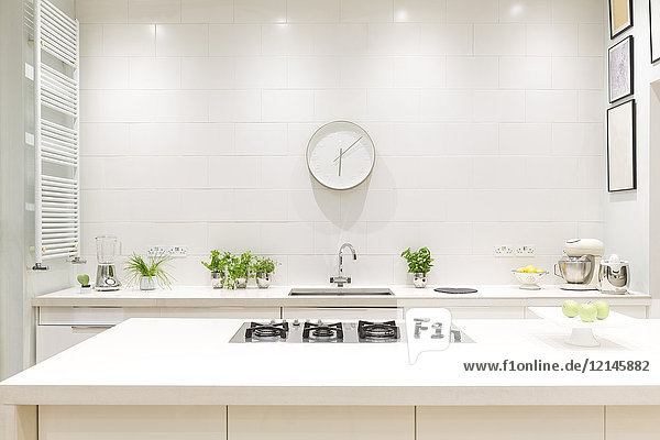 Weiße,  moderne,  luxuriöse Wohnküche mit Uhr