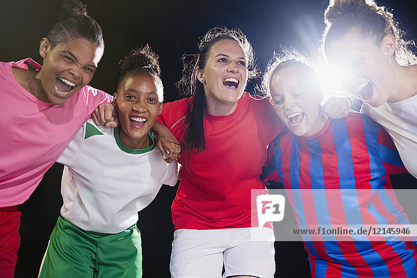 Portrait begeisterte  selbstbewusste junge Fußballmannschaft  die sich zusammenschließt und jubelt.
