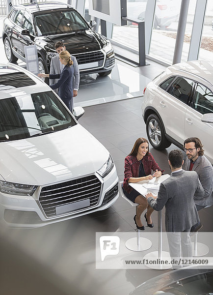 Autoverkäufer treffen sich am Tisch im Autohaus-Showroom
