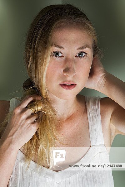 Young mysterious blonde woman looking into the camera.