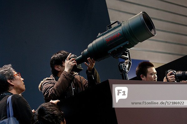 March 3  2018  Yokohama  Japan - A man tries out a Sigma's biggest Zoom lens 200-500mm f/2. 8 at the CP+ Camera & Photo Imaging Show 2018 in Pacifico Yokohama. Japan's largest camera and photo imaging exhibition bring together 1 123 exhibitor booths during the four-day trade show at the Pacifico Yokohama and OSANBASHI Hall. Organizers expect approximately 70 000 visitors until March 4th.