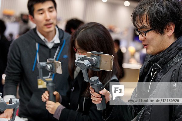 March 3,  2018,  Yokohama,  Japan - Visitors try out the new DJI OSMO MOBILE 2 at the CP+ Camera & Photo Imaging Show 2018 in Pacifico Yokohama. Japan's largest camera and photo imaging exhibition bring together 1, 123 exhibitor booths during the four-day trade show at the Pacifico Yokohama and OSANBASHI Hall. Organizers expect approximately 70, 000 visitors until March 4th.