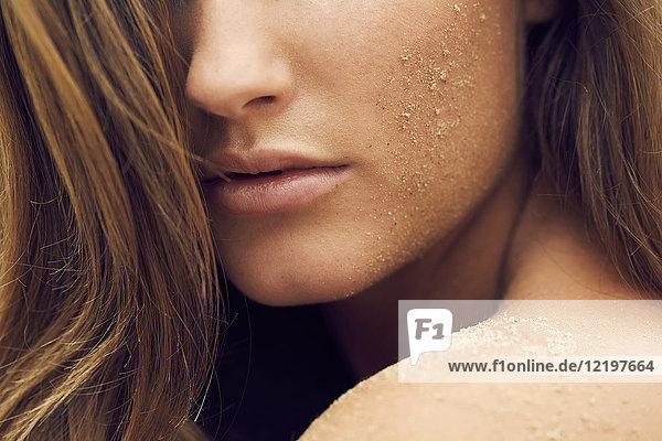 Woman with sand on her cheek  close-up