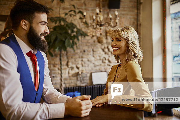 Elegant couple smiling at each other in a bar