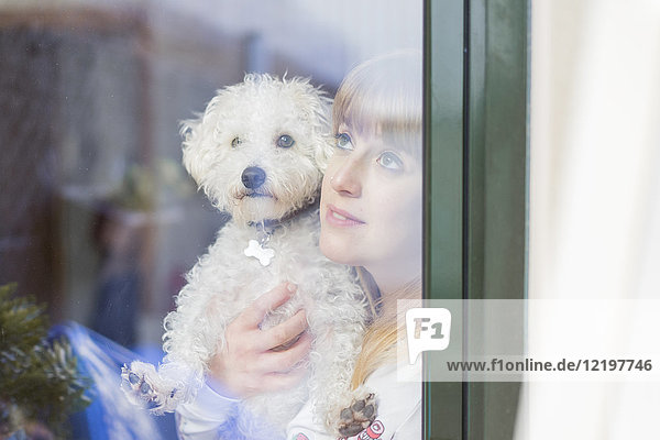 Woman and her dog looking out of window