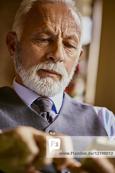 Eleganter älterer Mann mit Handy