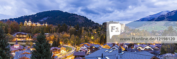 Schweiz  Kanton Bern  Gstaad  Stadtbild mit Gstaad Palace Hotel in der Abenddämmerung