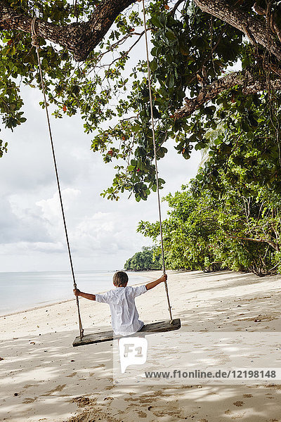 Thailand  Ko Yao Noi  Junge auf einer Schaukel am Strand