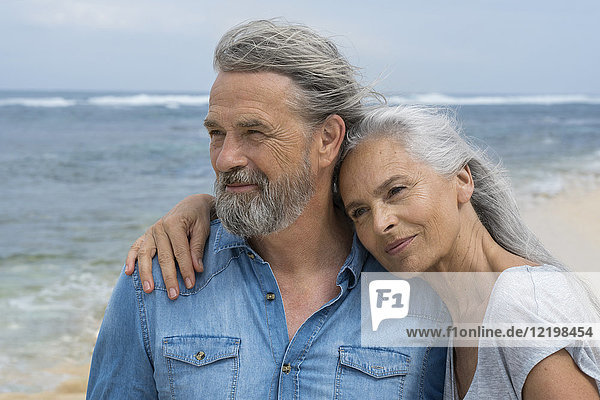 Hübsches Seniorenpaar  das sich am Strand umarmt