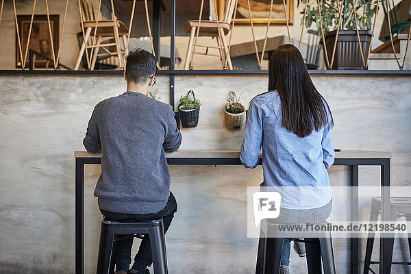 Rear view of young woman and man sitting in a cafe