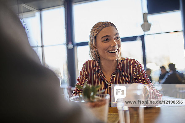 Portrait of laughing young woman in a cafe