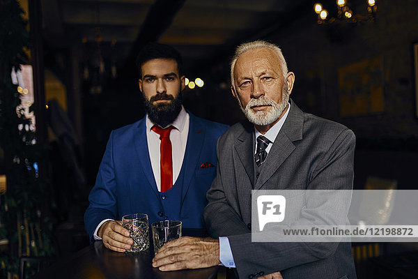 Porträt von zwei eleganten Männern in einer Bar mit Bechern