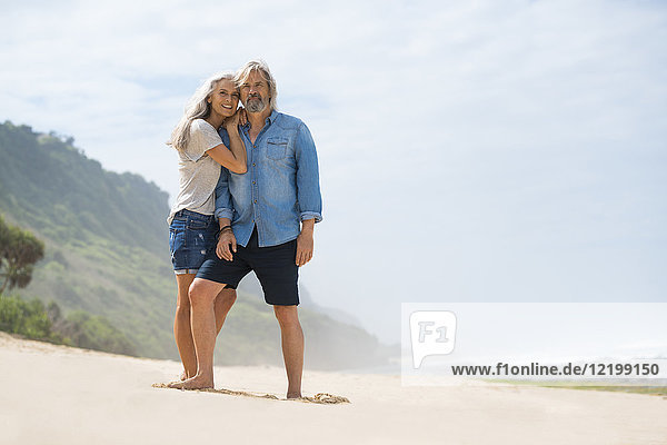Affectionate senior couple standing on the beach