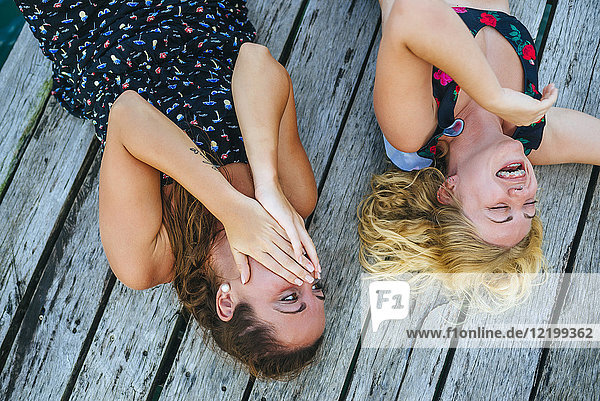 Panama  Bocas del Toro  Zwei lachende Frauen auf dem Holzsteg liegend