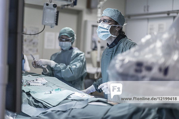 Neuroradiologe in Peelings während der Operation mit Blick auf den Monitor