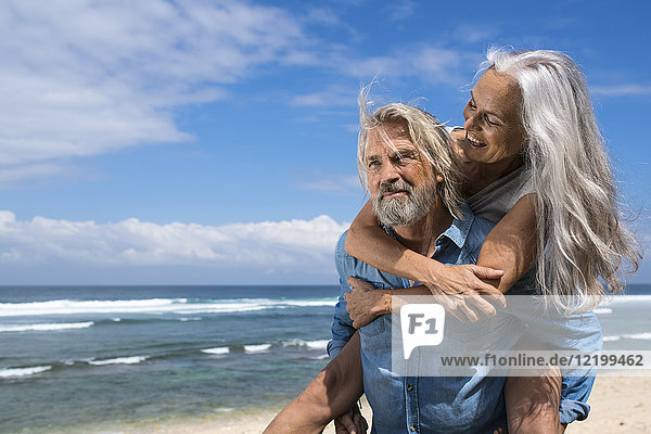 Hübsches Seniorenpaar mit Spaß am Strand