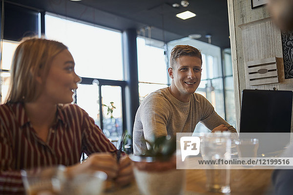 Smiling friends meeting in a cafe