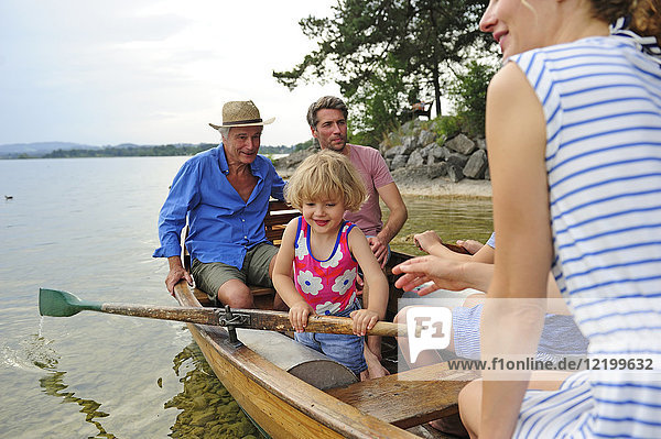 Germany  Bavaria  Murnau  happy little girl with her family in rowing boat at lakeshore