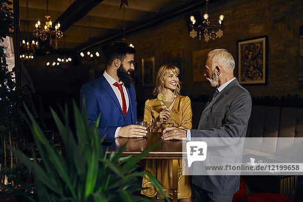 Zwei elegante Männer und Frauen  die sich in einer Bar treffen.