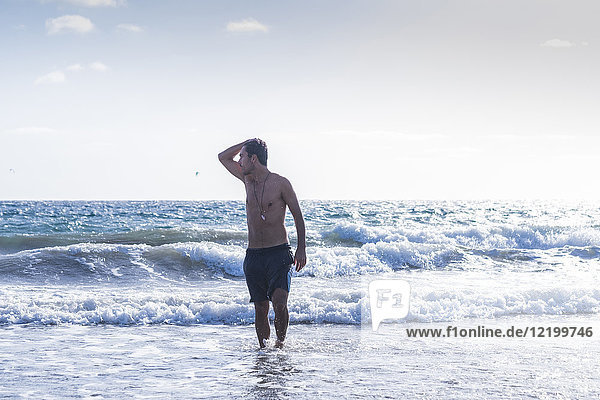 Young man coming out of the ocean