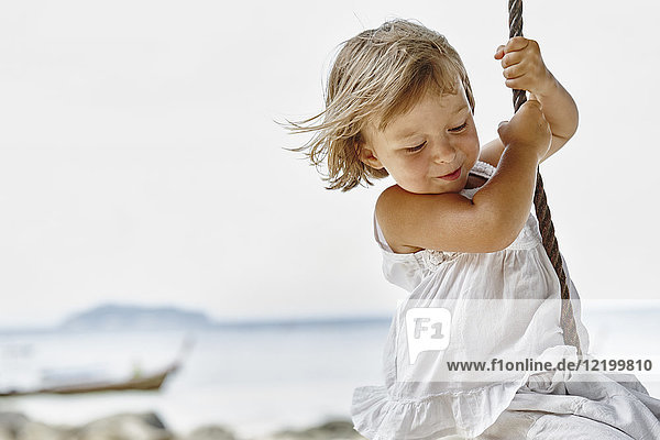 Thailand  Phi Phi Phi Inseln  Ko Phi Phi Phi  glückliches kleines Mädchen auf einer Seilschaukel am Strand