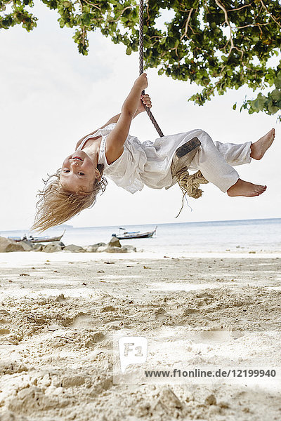 Thailand  Phi Phi Phi Inseln  Ko Phi Phi Phi  glückliches kleines Mädchen auf einer Seilschaukel am Strand
