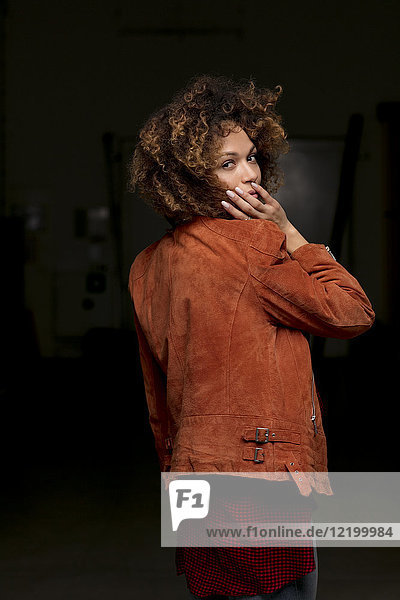 Porträt einer Frau mit Lederjacke vor dunklem Hintergrund