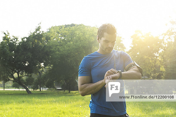 Läufer im Stadtpark überprüft seine Smartwatch