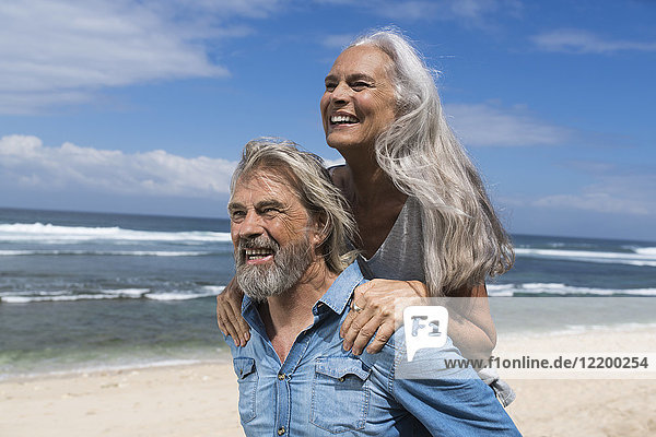 Hübsches Seniorenpaar mit Spaß am Strand