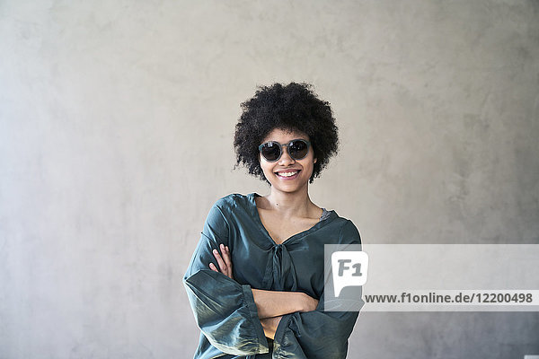 Porträt einer lächelnden jungen Frau mit Sonnenbrille
