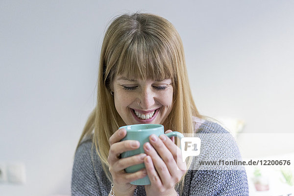 Portrait of laughing young woman with coffee mug