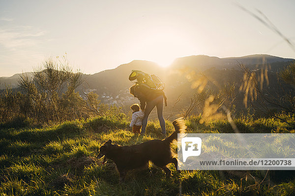 Spanien  Barcelona  Großmutter mit Enkelin und Hund während einer Wanderung bei Sonnenuntergang