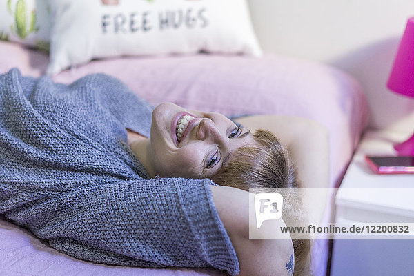 Laughing woman lying on bed
