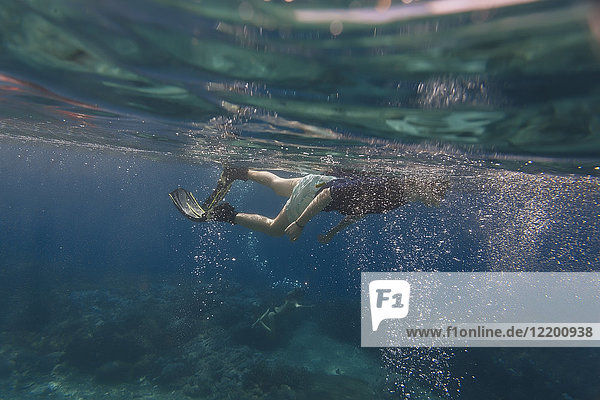 Unterwasseraufnahme eines Mannes mit Flossen und Schnorcheln
