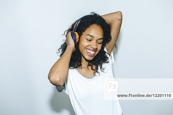 Portrait of happy young woman listening music with headphones