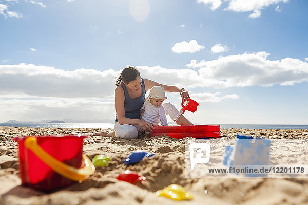 Mutter spielt mit kleiner Tochter am Strand