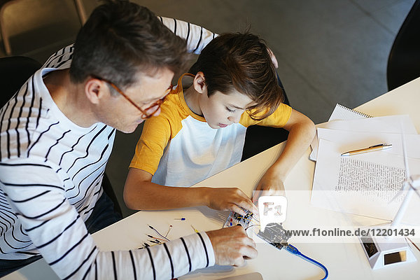 Father and son assembling a construction kit with wind turbine model