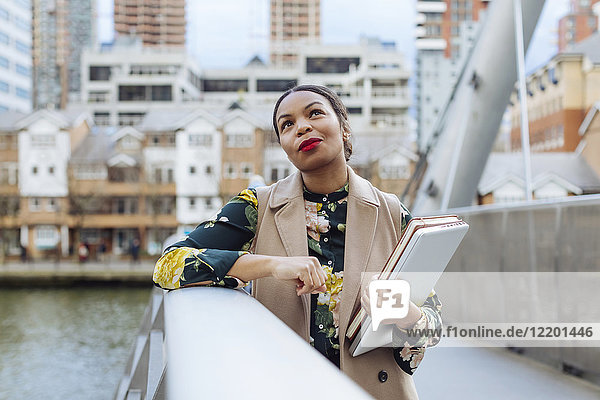 UK  London  portrait of fashionable businesswoman leaning on railing of bridge