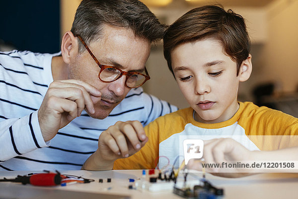 Vater und Sohn beim Zusammenbau eines elektronischen Baukastens